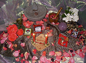 Preparing a mojo hand for love with a name paper, red candles, Dixie Love oil, roses, and love-drawing roots